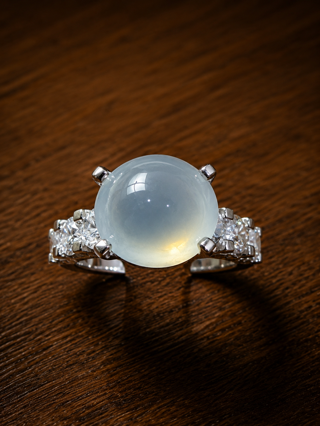 Nhẫn phỉ thúy Jadeite cabochon xanh băng thiên nhiên đính đá hai bên, thiết kế tối giản và sang trọng.